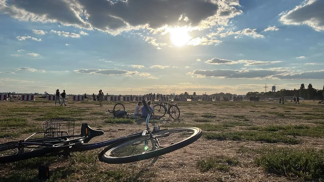 Pôr do sol no Tempelhofer Feld em Berlim com bicicletas na grama
